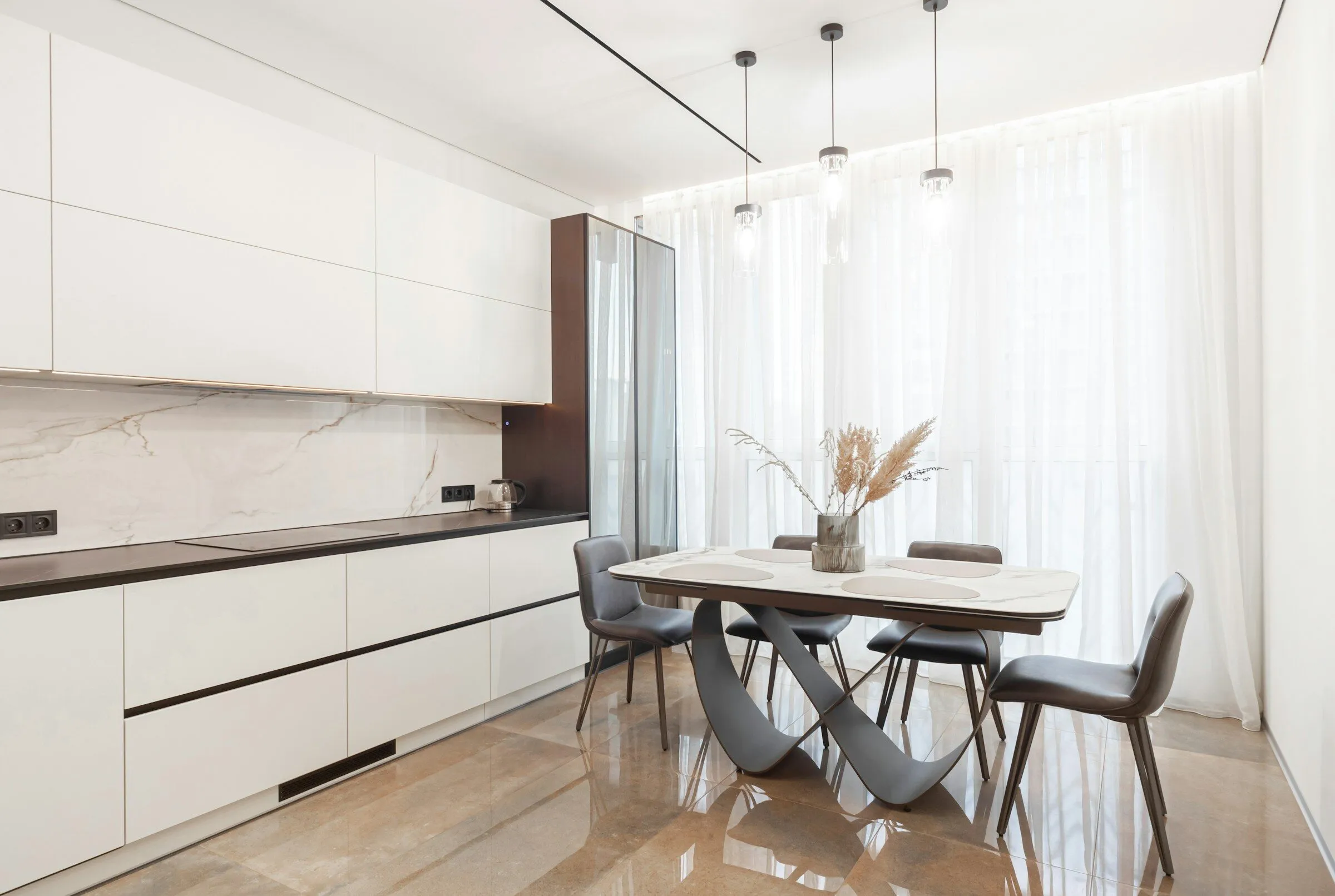 White kitchen and dining table in front of sheer curtains