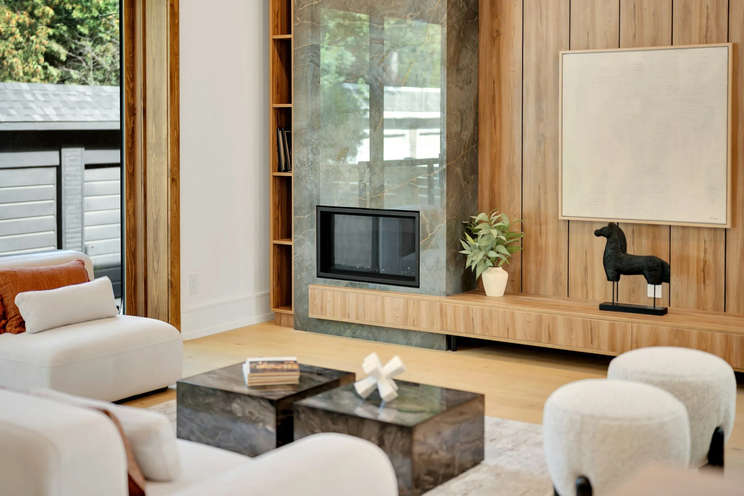 Living room with an oak-panelled wall, a fireplace and low white seating