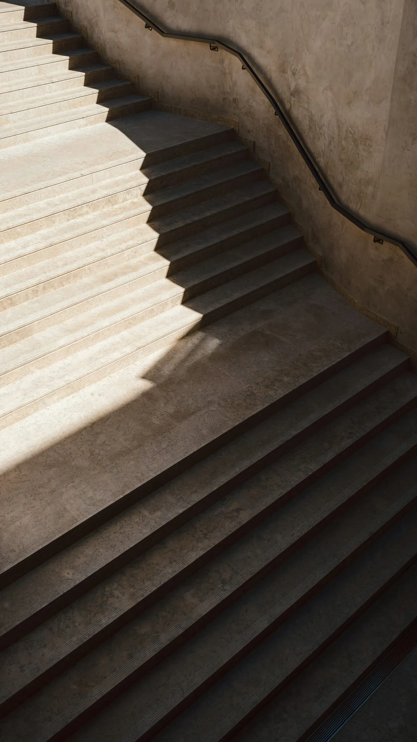 Concrete stair in strong sunlight with deep diagonal shadows